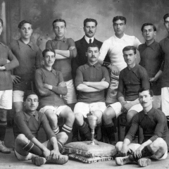 Posant amb el trofeu del Campionat de Catalunya conquistat amb el F.C. España. 1912-1913. Reguera, Bau (dempeus segon per l'esquerra), Olivé, Vernet, Baró, Mariné, Duval, Graells, Passani, Miguel, Ramirez